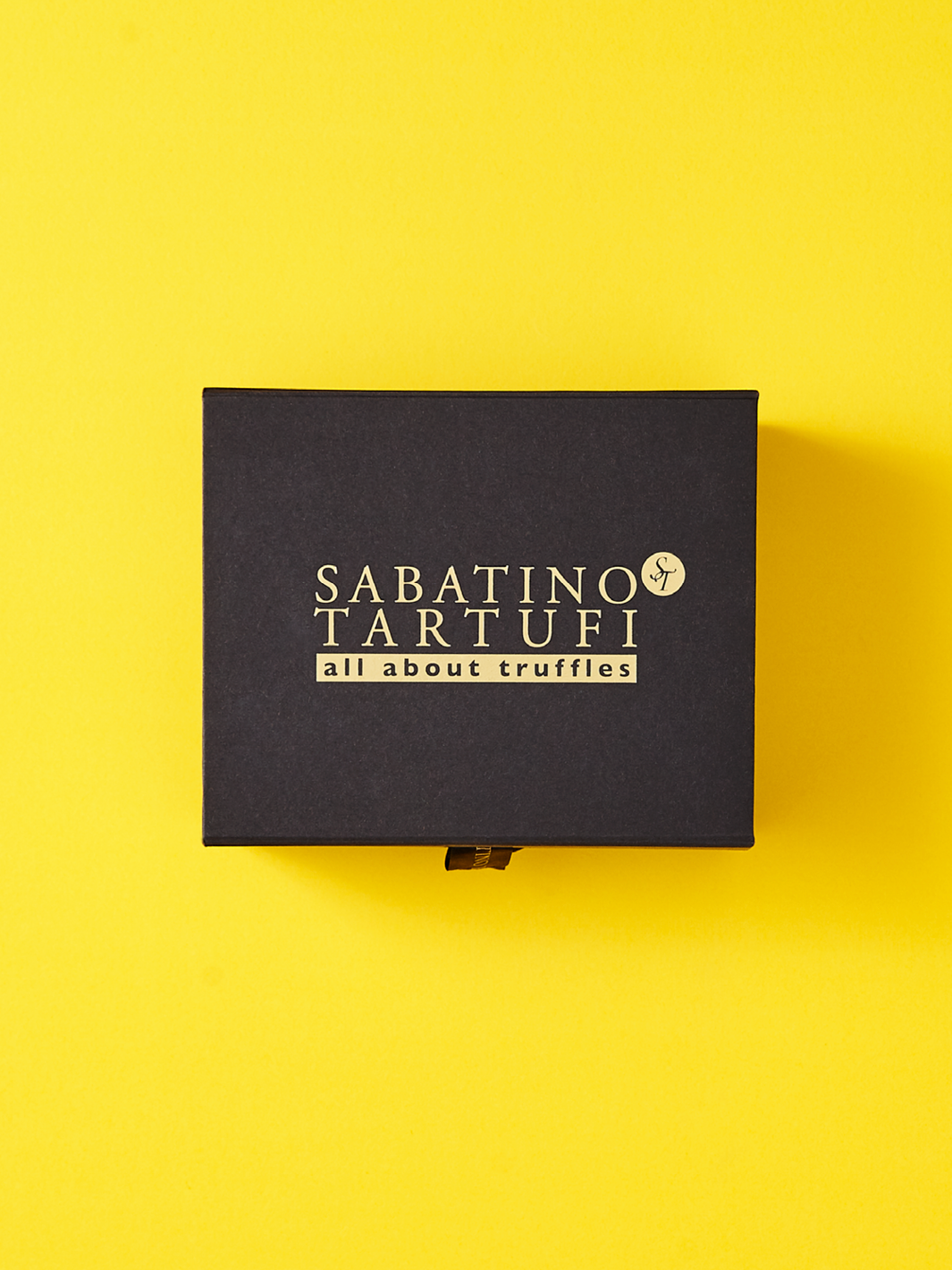 Black custom cardboard packaging on a yellow background. 