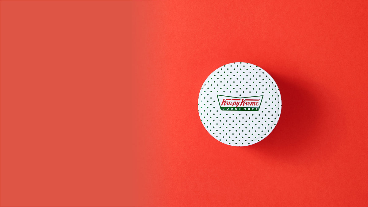 Krispy Kreme metal packaging on a red background. 