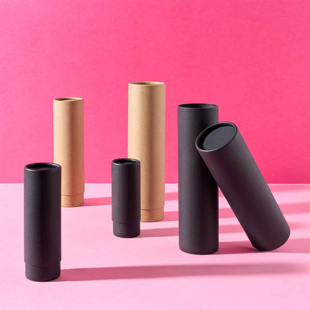 Collection of telescopic cardboard tubes in black and brown on a pink background. 