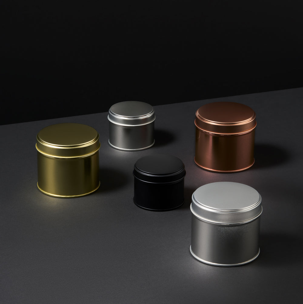 Collection of welded side seam tins in black, rose gold, silver, and gold