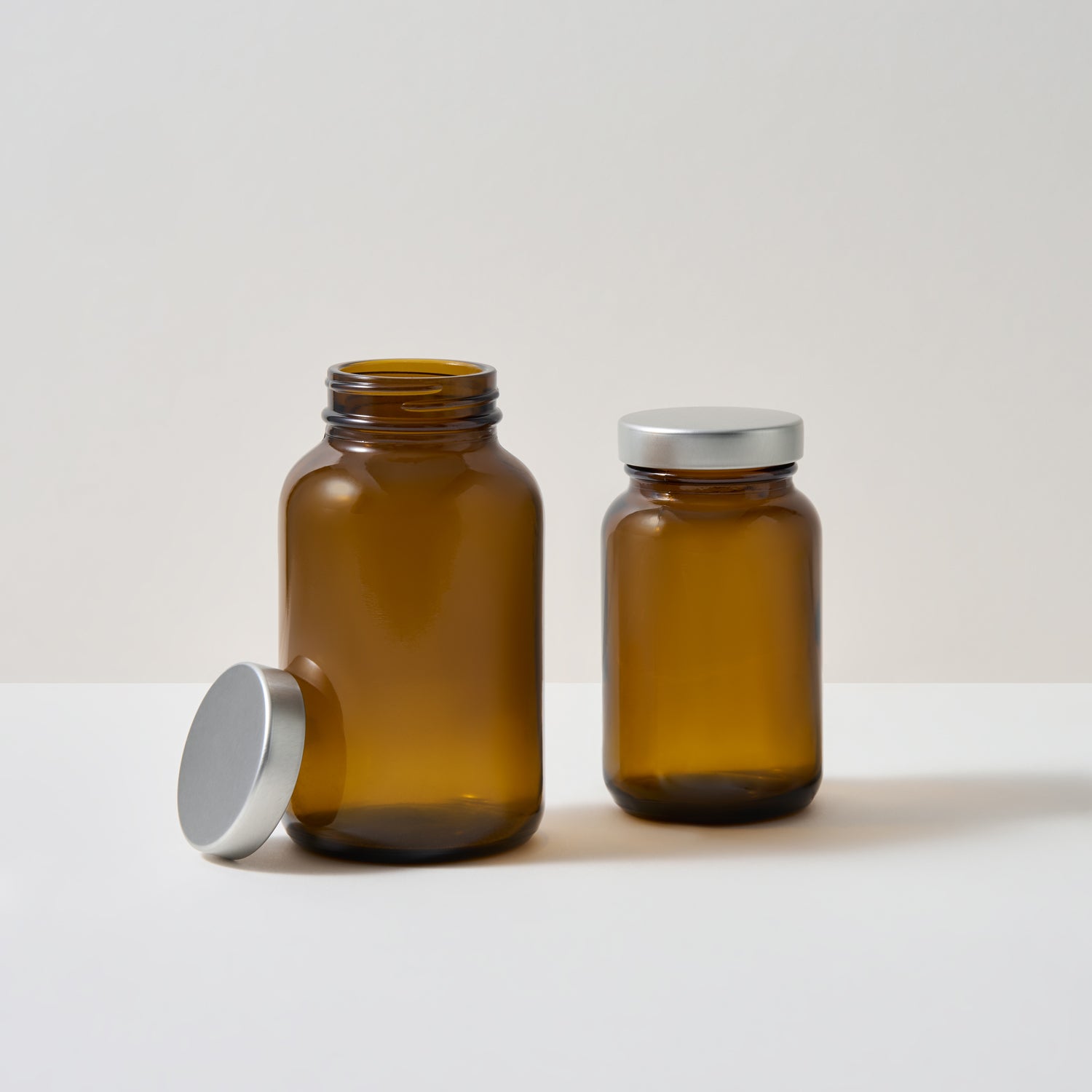 Collection of amber glass supplement jars on white background. 